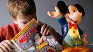 Ein Junge liest in einem Micky-Maus-Heft. © dpa picture alliance Foto: Ulrich Baumgarten