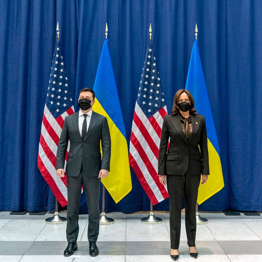 Die Vizepräsidentin der USA, Kamala Harris (rechts), steht neben dem Präsidenten der Ukraine, Wolodymyr Selenskyj (links), bei der Münchner Sicherheitskonferenz vor einem blauen Wandvorhang und den Nationalflaggen der USA und der Ukraine im Hintergrund. © AP Pool/AP/dpa Foto: Andrew Harnik