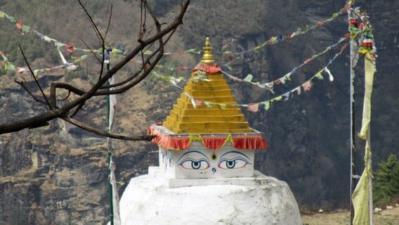 Gebetsfahnen an einem Tempel mit aufgemalten Augen. © NDR Info 