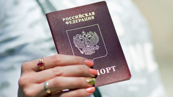 Eine Frau hält ihren russischen Pass in den Händen. © dpa Foto: Kay Nietfeld