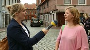 NDR Info Reporterin Bettina Less (links) interviewt eine junge Frau. © Screenshot 