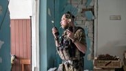 Ein ukrainischer Soldat hält ein Funkgerät während schwerer Kämpfe an der Front in Sjewjerodonezk in der Region Luhansk. © dpa/AP Foto: Oleksandr Ratushniak