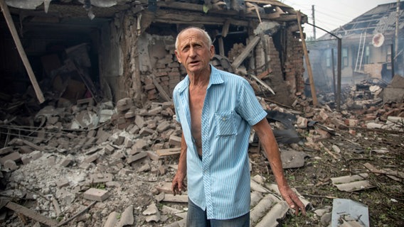 Der 71-jährige Wladimir Wassiljewitsch steht im Hof des zerstörten Hauses seiner Verwandten nach Raketenangriffen auf die ostukrainische Stadt Slowjansk in der Region Donezk. © ZUMA Press Wire/dpa Foto: Michal Burza