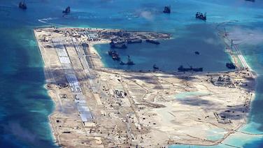 Ein Luftbild zeigt das Fiery Cross Reef der Spratly Inseln im südchinesischen Meer mit chinesischen Schiffen und von China errichteten Gebäuden. © dpa picture alliance Foto: Ho