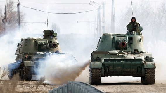 Zwei russische Panzer rollen auf einer Straße in der Ukraine. © imago images/ITAR-TASS Foto: Sergei Malgavko