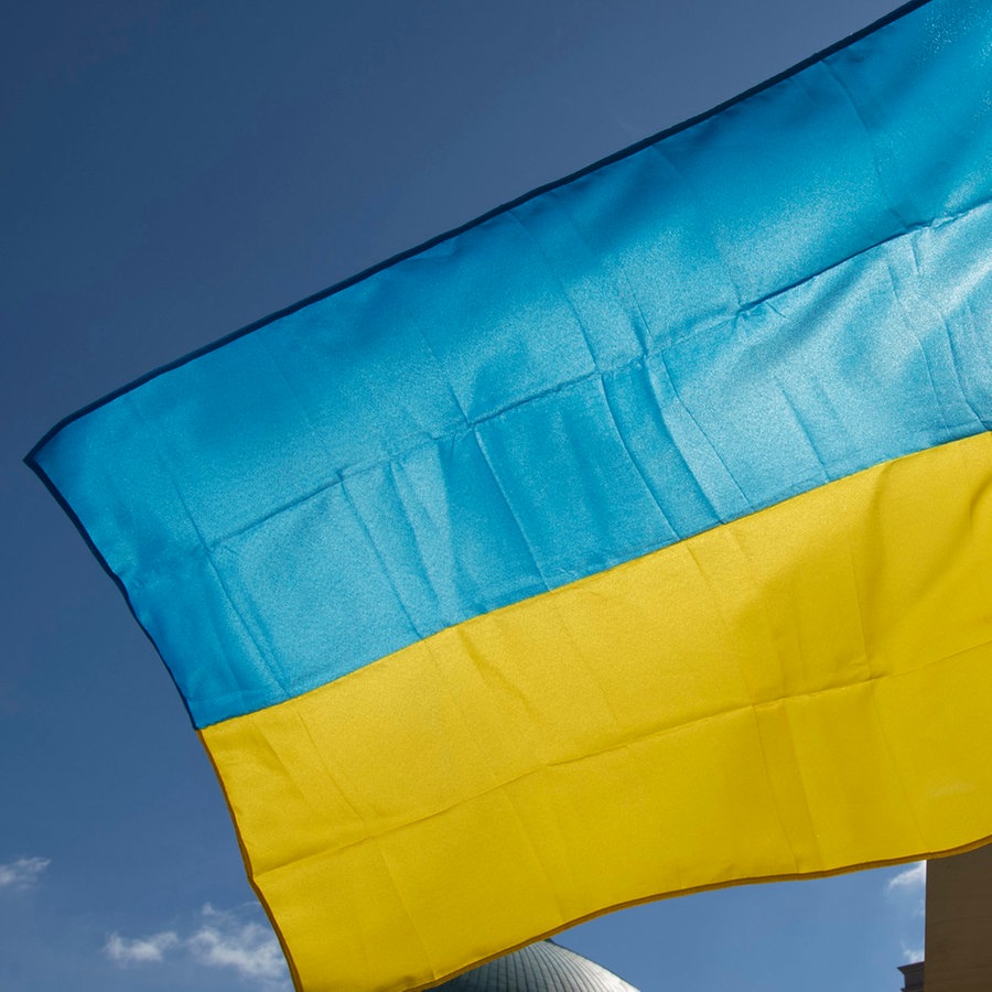 Eine Fahne der Ukraine weht im Wind bei der Demonstration gegen den Krieg in der Ukraine. © dpa Foto: Paul Zinken