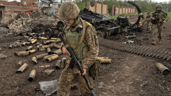 Ukrainische Soldaten patrouillieren in einem kürzlich zurückeroberten Dorf nördlich von Charkiw in der Ostukraine. © dpa Foto: Mstyslav Chernov