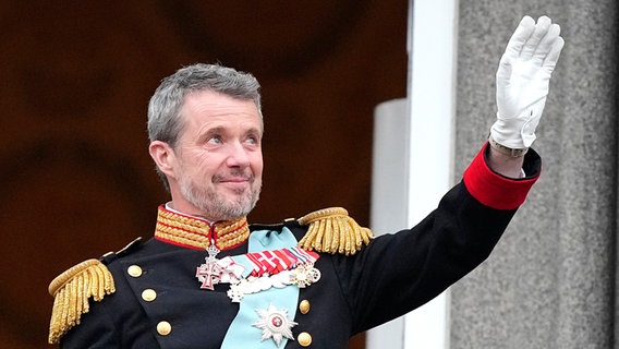 Der dänische König Frederik X. lächelt mit gerührtem Blick und hebt eine Hand mit weißem Handschuh in die Höhe © Martin Meissner/AP/dpa +++ dpa-Bildfunk +++ Foto: Martin Meissner