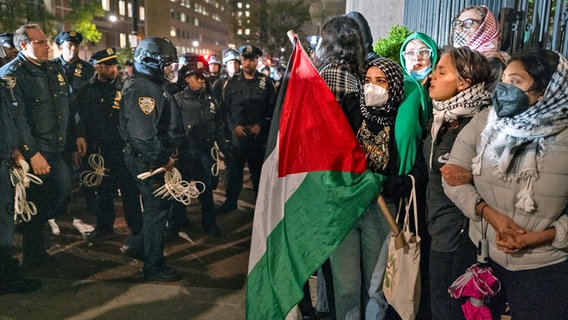 Demonstranten halten sich in der Nähe des Haupteingangs der Columbia University in New York auf, während Polizeibeamte der Stadt New York das Gebiet räumen, nachdem ein Gebäude auf dem Campus von Demonstranten besetzt worden war. © Craig Ruttle/AP/dpa 
