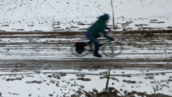 Ein Radfahrer fährt in Hamburg auf einem von Schnee und Schneematsch überzogenen Weg. © picture alliance / Axel Heimken/dpa Foto: Axel Heimken