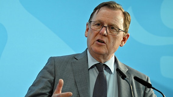 Bodo Ramelow (Die Linke), Ministerpräsident von Thüringen, spricht während einer Pressekonferenz in ein Mikrofon. © dpa bildfunk Foto: Martin Schutt