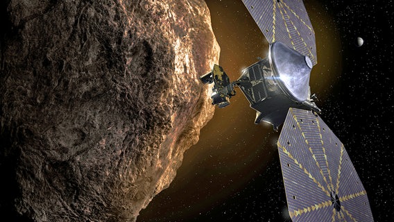 Die Illustration zeigt die Annäherung der NASA-Sonde "Lucy" an einen Asteroiden. Die Raumsonde ist im Oktober 2021 gestartet. Sie soll sechs Asteroiden aus der Gruppe der Jupiter-Trojaner erforschen. © picture alliance / ASSOCIATED PRESS | Uncredited 