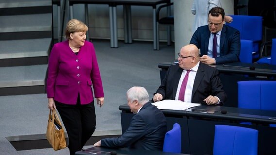 Bundeskanzlerin Angela Merkel (l, CDU) kommt zur Plenarsitzung des Deutschen Bundestages. Auf der Regierungsbank sitzen Horst Seehofer (l-r, CSU), Peter Altmaier (CDU) und Jens Spahn (CDU). © dpa Foto: Bernd von Jutrczenka