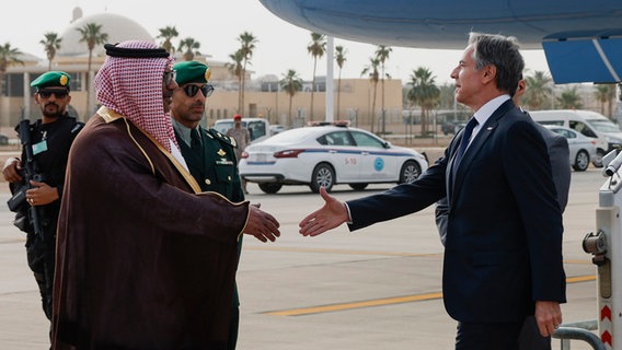 US-Außenminister Antony Blinken wird von Mohammed Al-Ghamdi, dem Direktor des saudischen Außenministeriums für protokollarische Angelegenheiten, bei seiner Ankunft in Riad, Saudi-Arabien begrüßt. © Evelyn Hockstein/Reuters Pool via AP/dpa 