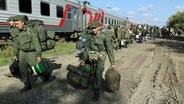 Russische Rekruten gehen nach Beginn der Teil-Mobilisierung für den Krieg in der Ukraine auf einem Bahnhof in Prudboi in der Region Wolgograd zum Zug. (Foto vom 29.9.2022) © Uncredited/AP/dpa 