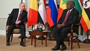 Auf diesem, von der Fotoagentur RIA Novosti zur Verfügung gestellten Foto unterhält sich der russische Präsident Wladimir Putin (l.) mit dem südafrikanischen Präsidenten Cyril Ramaphosa nach einem Treffen mit einer Delegation afrikanischer Staatsoberhäupter in St. Petersburg. ©  Ramil Sitdikov/Photo host Agency RIA Novosti via AP/dpa 