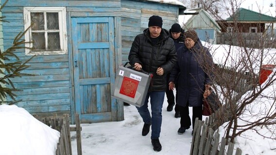 Omsk: Mitglieder einer Wahlkommission mit einer Wahlurne © ---/AP/dpa +++ dpa-Bildfunk Foto: ---/AP/dpa