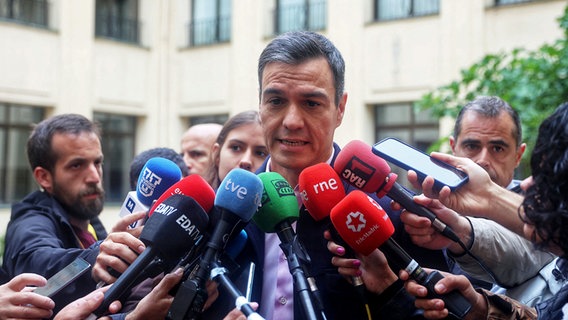 Spaniens Ministerpräsident Pedro Sanchez von der Sozialistischen Arbeiterpartei (PSOE) spricht in mehrere Mikrofone von Journalisten. © dpa-Bildfunk/EUROPA PRESS Foto: Ricardo Rubio