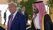 US-Präsident Donald Trump spricht mit dem saudischen Kronprinzen Mohammed bin Salman (M. r) während einer Ankunftszeremonie im Royal Terminal des King Khalid International Airport in Riad. © Alex Brandon/AP/dpa 