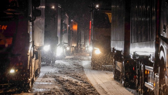 Lastkraftwagen stauen sich auf der Autobahn A5 bei Grünberg auf schneebedeckter Fahrbahn. © dpa Bildfunk Foto: Bernd März