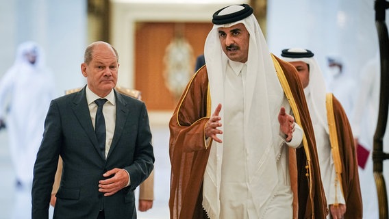 Bundeskanzler Olaf Scholz und der Emir von Katar, Tamim bin Hamad Al Thani, unterhalten sich im Gehen. © Kay Nietfeld/dpa 