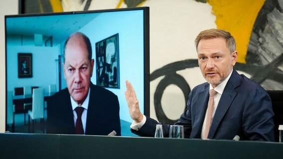 Finanzminister Lindner (re.) und Bundeskanzler Olaf Scholz, der auf einem Monitor auf der PK eingeblendet wird, stellen Pläne zum Energiepreisdeckel vor. © dpa Foto: Kay Nietfeld