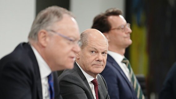 Bundeskanzler Olaf Scholz (M, SPD), Stephan Weil (SPD, vorn), Ministerpräsident von Niedersachsen, und Hendrik Wüst (CDU), Ministerpräsident von Nordrhein-Westfalen, geben nach der Ministerpräsidentenkonferenz in Berlin eine Pressekonferenz. © dpa Foto: Kay Nietfeld