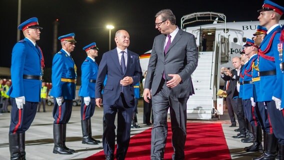 Bundeskanzler Olaf Scholz (SPD), wird von Aleksandar Vucic, Präsident von Serbien, am Flughafen in Belgrad begrüsst. © Michael Kappeler/dpa 