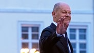 Der geschäftsführende Bundeskanzler Olaf Scholz (SPD) verlässt nach der Übergabe der Entlassungsurkunden durch Bundespräsident Steinmeier winkend das Schloss Bellevue. © picture alliance/dpa | Michael Kappeler Foto: Michael Kappeler