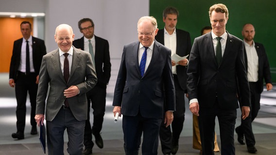 Bundeskanzler Olaf Scholz zusammen mit den Ministerpräsidenten Stephan Weil und Hendrik Wüst auf dem Weg zur Pressekonferenz. © Bernd von Jutrczenka/dpa Foto: Bernd von Jutrczenka