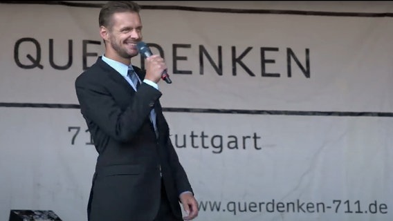 Der Kabarettist Florian Schroeder bei einem Auftritt auf einer Bühne. © Youtube/Screenshot 