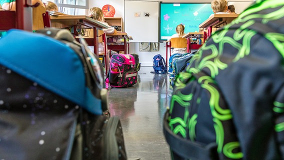 Schultaschen stehen in einem Klassenraum einer Grundschule auf dem Boden. © picture alliance/dpa Foto: Frank Hammerschmidt