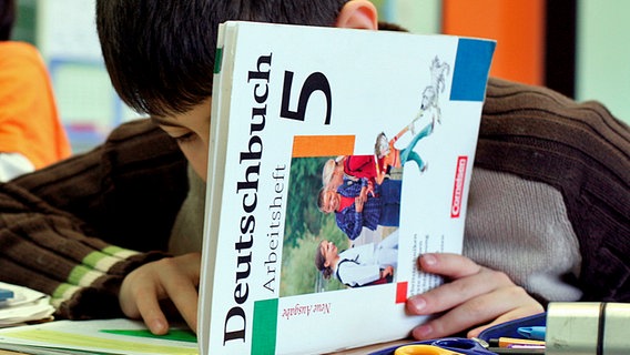 Ein Schüler blättert während des Deutschunterrichts in einem Schulbuch. © dpa picture alliance Foto: Karl-Josef Hildenbrand