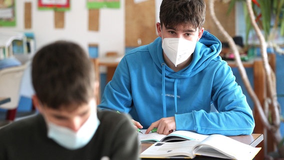 Zwei Schüler sitzen im Unterricht in einem Klassenraum und tragen eine medizinische Maske © picture alliance / Eibner-Pressefoto Foto: Fleig / Eibner-Pressefoto