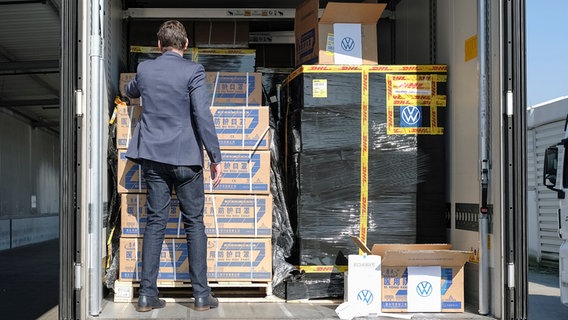 VW-Personalvorstand Gunnar Kilian betrachtet eine Lieferung von 400.000 Atemschutzmasken in einem Lkw. © dpa bildfunk Foto: Ole Spata