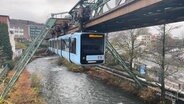 Die Schwebebahn fährt an ihrem Gerüst über der Wupper. © NDR Foto: Daniel Sprenger
