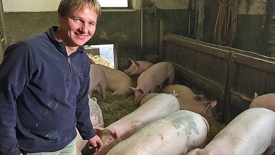 Ein Bauer steht mit seinen Schweinen im Stall. © NDR Info Foto: Claudia Plass