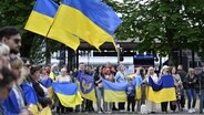 Menschen haben sich in Luzern in der Schweiz zu einer Friedenskundgebung für die Ukraine versammelt © Walter Bieri/KEYSTONE/dpa Foto: Walter Bieri/KEYSTONE/dpa