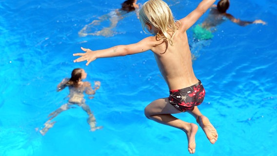 Ein Junge springt in ein Schwimmbecken. © picture alliance / dpa Foto: Stefan Puchner