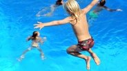 Ein Junge springt in ein Schwimmbecken. © picture alliance / dpa Foto: Stefan Puchner