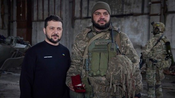 Auf diesem vom Pressebüro des ukrainischen Präsidenten zur Verfügung gestellten Foto stehen Wolodymyr Selenskyj (M), Präsident der Ukraine, und ein Soldat in einer Stellung in der Nähe von Bachmut nebeneinander. © Uncredited/Ukrainian Presidential Press Office/AP 