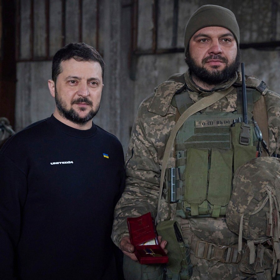 Auf diesem vom Pressebüro des ukrainischen Präsidenten zur Verfügung gestellten Foto stehen Wolodymyr Selenskyj (M), Präsident der Ukraine, und ein Soldat in einer Stellung in der Nähe von Bachmut nebeneinander. © Uncredited/Ukrainian Presidential Press Office/AP 