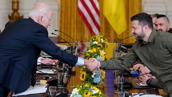 US-Präsident Joe Biden und der ukrainische Präsident Wolodymyr Selenskyj reichen sich im Weißen Haus die Hände. © dpa-Bildfunk/Evan Vucci/AP 