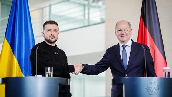 Berlin: Wolodymyr Selenskyj, Präsident der Ukraine, und Bundeskanzler Olaf Scholz (r, SPD) geben sich bei einer Pressekonferenz nach ihrem Gespräch im Bundeskanzleramt im Mai 2023 die Hand. © dpa Foto: Kay Nietfeld/