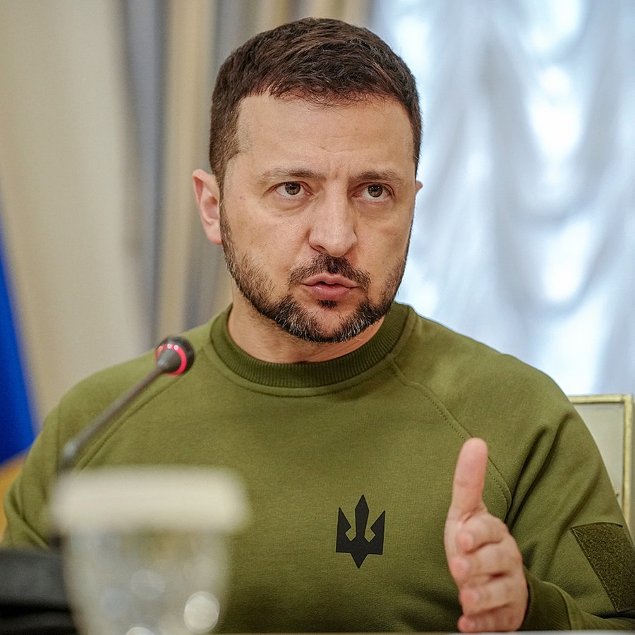 Wolodymyr Selenskyj, Präsident der Ukraine, sitzt an einem Tisch, auf dem vor ihm ein Mikrofon steht. © dpa bildfunk Foto: Kay Nietfeld