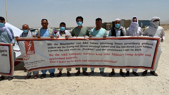 Afghanische Ortskräfte weisen mit einem Plakat auf ihre schwierige Situation hin. © NDR Foto: Silke Diettrich