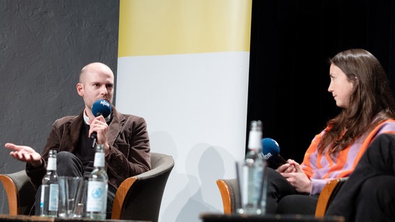 Diskussionsrunde am 8.5.2025 im resonazraum in Hamburg zum Thema Zukunfsfähiges Wirtschaften. Auf dem Podium von links nach rechts: Lukas Bäuerle und Carla Reuter. © AdWHH Foto: AdWHH / Jann Wilken