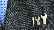 Ein Anzug mit kleinen Schraubenschlüsseln in der Brusttasche © phantermedia Foto: johnkwan