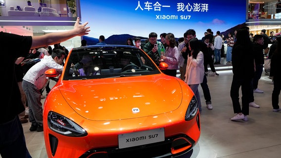 Besucher der Automesse Peking betrachten ein  Xiaomi SU 7 E-Auto. © picture alliance Foto: Andy Wang