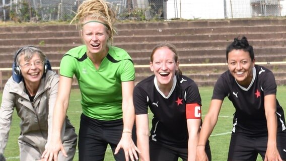 Autorin Martina Keller mit Fußballspielerinnen auf dem Platz. © Leo Schulte Foto: Leo Schulte